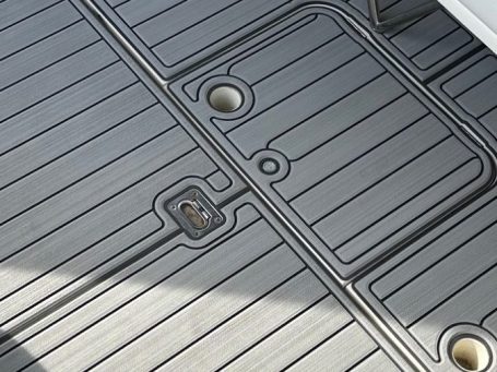 zoom sur un revêtement de pont sur mesure Surface de bateau avec texture en mousse EVA rainurés, comprenant des trous ronds.