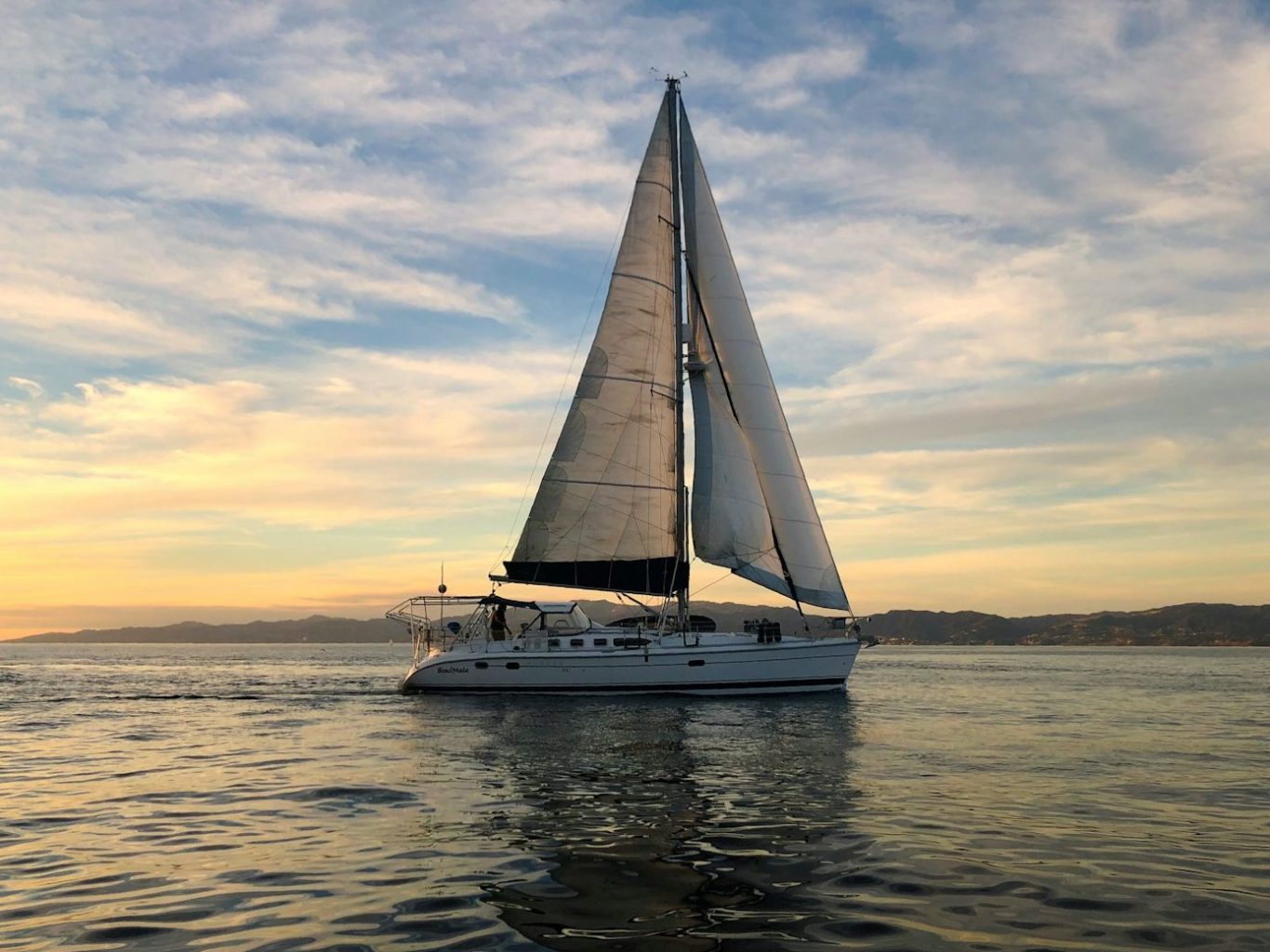 Plancher de bateau Un voilier naviguant sur des eaux calmes au crépuscule, avec des voiles déployées et son revêtement de pont.